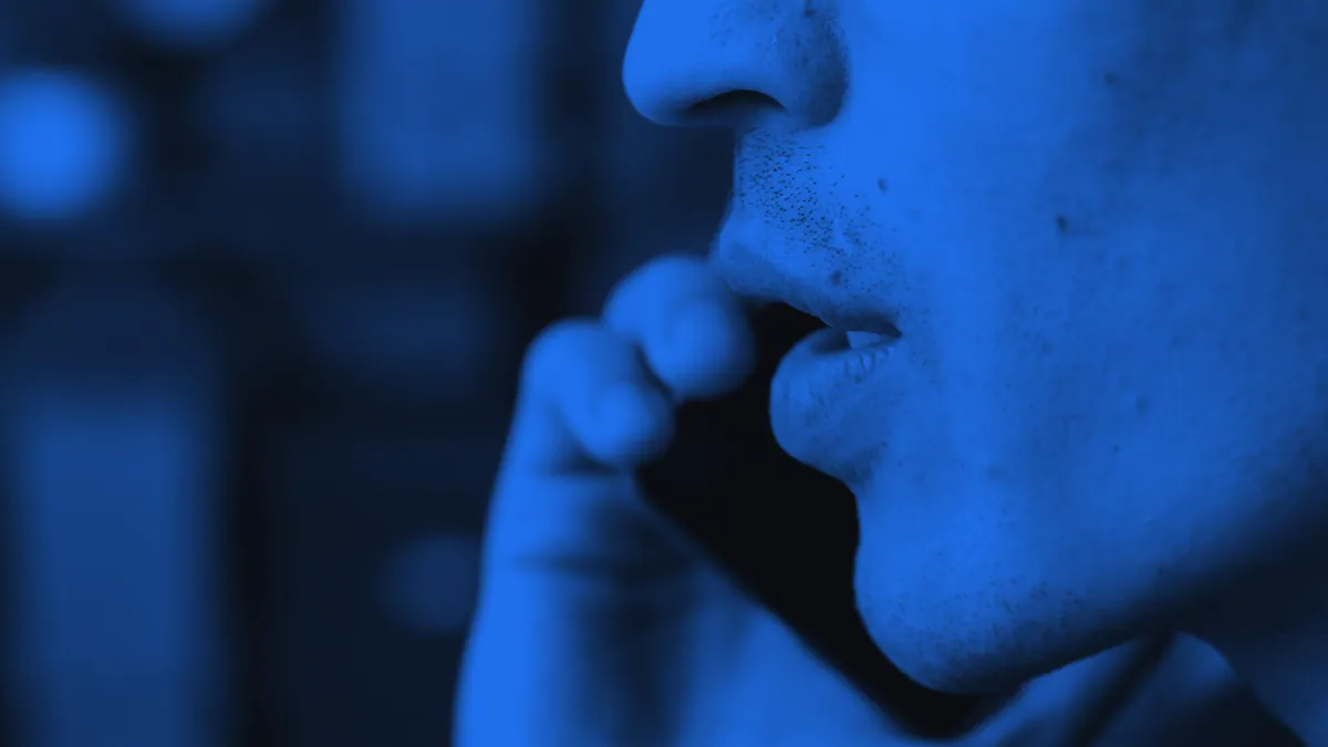 A person interacting with a mobile device via voice commands.