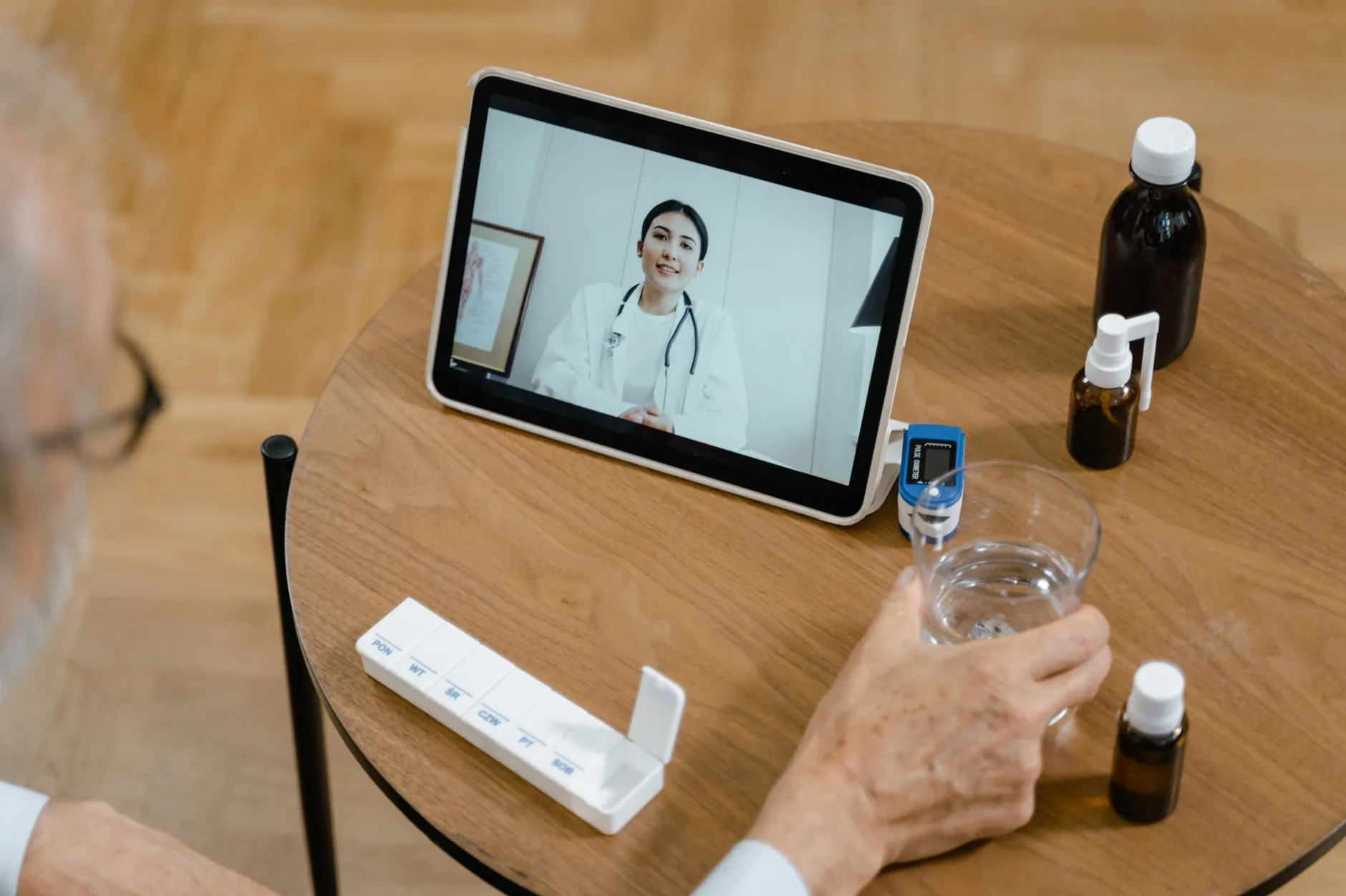 A person using a tablet on a wooden desk in a minimalist room, PECS communication system.